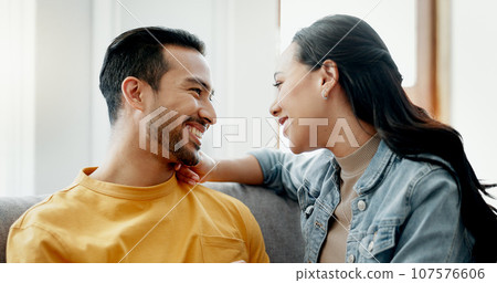 Conversation, funny and couple on sofa in home living room, bonding and having fun. Smile, communication of man and woman in lounge for healthy connection of love, happy or laughing together in house 107576606