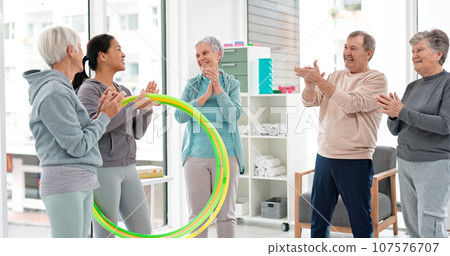 Fitness, senior and people with celebration at gym at end or exercise class for wellness. Elderly, group and friends in studio to congratulation after workout in retirement with coach and hula hoop. 107576707