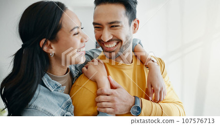 Home, hug and couple with love, marriage and smile with romance, relationship and loving together. Lounge, man and woman embrace, romantic and support with moment, bonding and care with happiness 107576713