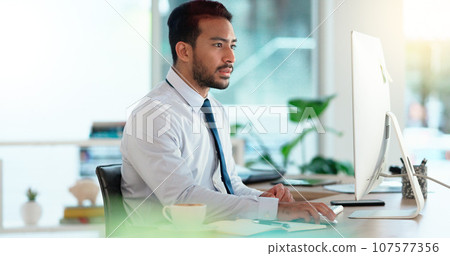 Busy male Accountant typing an email in a modern office. A financial advisor compiling a finance proposal for a successful company. A serious Auditor writing a business investment report 107577356