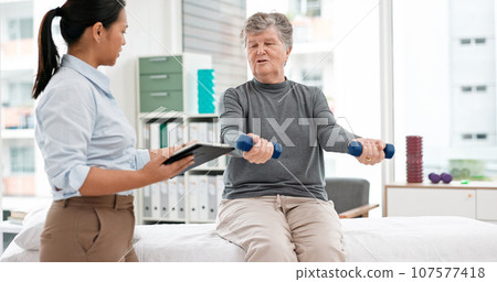 Physiotherapy tablet, senior woman and dumbbell for muscle, fitness and stretching support on digital checklist. Physical therapy, medical or chiropractor person helping elderly patient with exercise Physiotherapy tablet, senior woman and dumbbell for muscle, fitness and stretching support on digital checklist. Physical therapy, medical or chiropractor person helping elderly patient with exercise 107577418