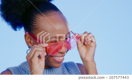 Fun, sunglasses and smile, black woman in studio with cool, trendy summer fashion and creative mockup. Happiness, luxury eyewear and excited model with designer frame on blue background for eye care. Fun, sunglasses and smile, black woman in studio with cool, trendy summer fashion and creative mockup. Happiness, luxury eyewear and excited model with designer frame on blue background for eye care. 107577443
