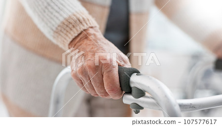 Hands, walker and an old person with a disability in recover or rehabilitation in a clinic for mobility and stability. Healthcare, medical and physiotherapy with a senior patient in a nursing home Hands, walker and an old person with a disability in recover or rehabilitation in a clinic for mobility and stability. Healthcare, medical and physiotherapy with a senior patient in a nursing home 107577617