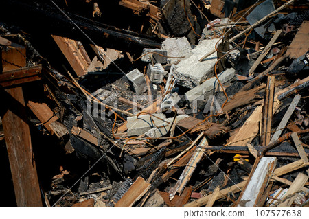 A burnt-out old wooden building after a fire. Charred beams after the destruction. 107577638