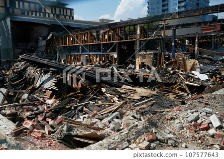 A burnt-out old wooden building after a fire. Charred beams after the destruction. A burnt-out old wooden building after a fire. Charred beams after the destruction. 107577643
