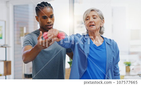 Senior woman, nurse and rehabilitation with dumbbells exercise in a nursing home for fitness. Elderly patient with a therapist man for healing, health and physiotherapy for arms, muscle and body 107577665