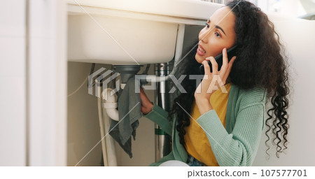 Sink leak, plumbing and woman on a phone call for maintenance, plumber service and home construction. Communication, manual labour and stressed girl calling handyman for faucet, pipes or kitchen leak 107577701