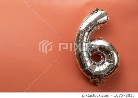 6 six metallic balloon isolated on pink background. Greeting card silver foil balloon number Happy birthday holiday concept. Copy space for text. Celebration party congratulation 107578035