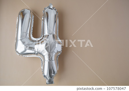 4 four metallic balloon on beige neutral background. Greeting card silver foil balloon number Happy birthday holiday concept. Copy space for text. Celebration party congratulation 4 four metallic balloon on beige neutral background. Greeting card silver foil balloon number Happy birthday holiday concept. Copy space for text. Celebration party congratulation 107578047