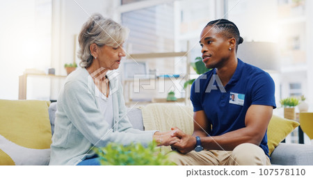 Black man, caregiver or old woman holding hands for support or empathy in cancer rehabilitation. Medical healthcare advice, senior person or male nurse nursing, talking or helping elderly patient 107578110