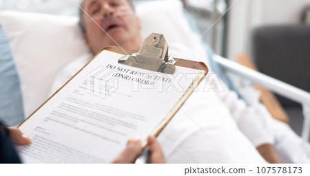 Hospital, patient and doctor with dnr form on clipboard for medical service, sick and do not resuscitate. Healthcare, cancer and health worker with application for senior man for insurance in clinic 107578173