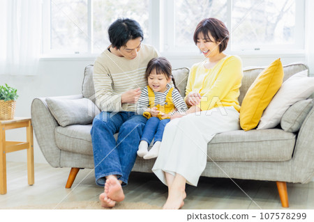 友善的父母和孩子坐在沙發上 友善的父母和孩子坐在沙發上 107578299