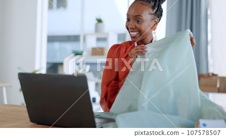 Fashion designer, fabric and black woman on video call on laptop with texture, pattern and material for client. Creative business, workshop and person on computer for clothes, shopping or boutique Fashion designer, fabric and black woman on video call on laptop with texture, pattern and material for client. Creative business, workshop and person on computer for clothes, shopping or boutique 107578507