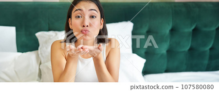 Beautiful korean girlfriend, girl in bed, sending air kiss at camera, lying in bed in her bedroom, waking up early Beautiful korean girlfriend, girl in bed, sending air kiss at camera, lying in bed in her bedroom, waking up early 107580080