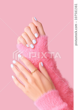Womans hands with white manicure on pink background Womans hands with white manicure on pink background 107581381