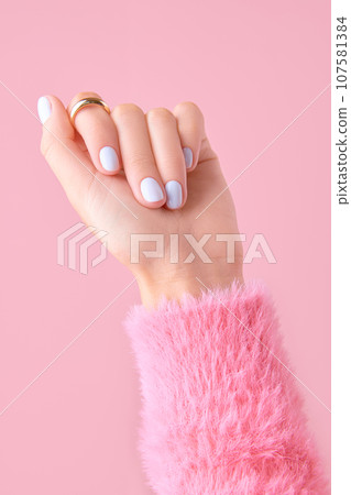 Womans hand with white nail design on pink background. Manicure, pedicure beauty salon concept Womans hand with white nail design on pink background. Manicure, pedicure beauty salon concept 107581384