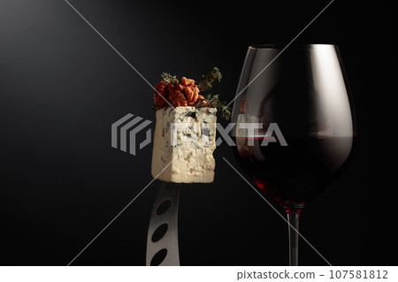 Glass of red wine and blue cheese. 107581812