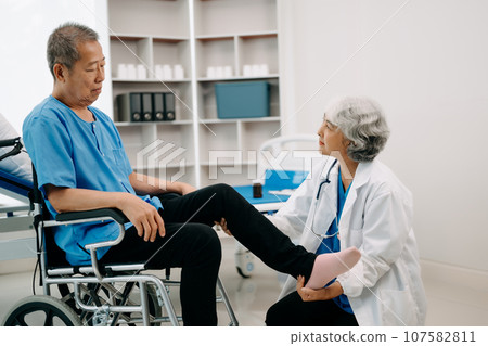 Asian physiotherapist helping elderly man patient stretching arm during exercise correct with dumbbell in hand during training hand in bed in clinic Asian physiotherapist helping elderly man patient stretching arm during exercise correct with dumbbell in hand during training hand in bed in clinic 107582811