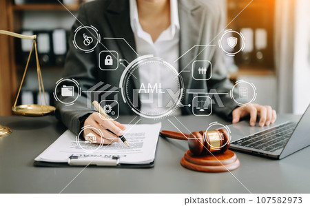 AML Anti Money Laundering Financial Bank Business Concept. judge in a courtroom using laptop and tablet with AML anti money laundering icon on virtual  screen. . 107582973