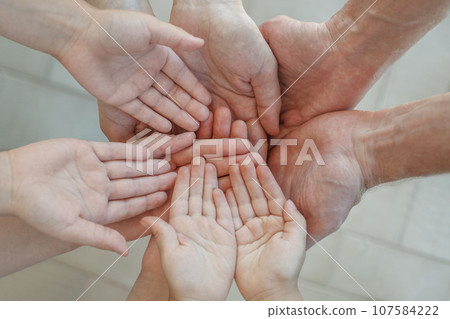 Closeup top view of human palm hands, parents and kid holding empty free space on hand together 107584222