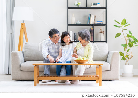 A senior couple with their granddaughter 107584230