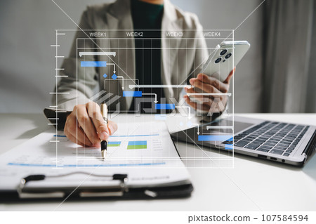 Project manager working and update tasks with milestones progress planning and Gantt chart scheduling diagram. business working with smart phone, tablet and laptop . 107584594