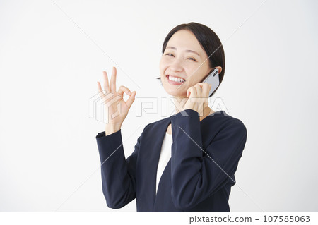 白色背景的女商人在打電話時打出“OK”手勢 107585063