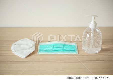 Medical face mask with alcohol sanitizer gel hand wash on wood table for covid-19 Coronavirus prevention concept 107586860