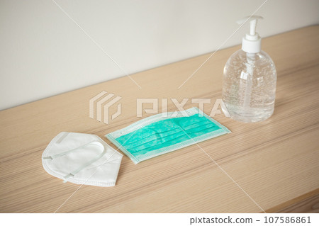 Medical face mask with alcohol sanitizer gel hand wash on wood table for covid-19 Coronavirus prevention concept 107586861