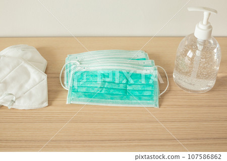 Medical face mask with alcohol sanitizer gel hand wash on wood table for covid-19 Coronavirus prevention concept 107586862