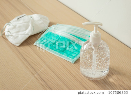 Medical face mask with alcohol sanitizer gel hand wash on wood table for covid-19 Coronavirus prevention concept 107586863