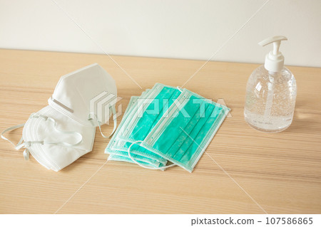 Medical face mask with alcohol sanitizer gel hand wash on wood table for covid-19 Coronavirus prevention concept 107586865