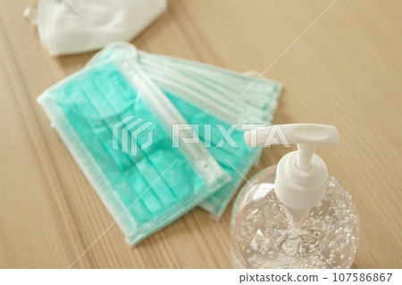 Medical face mask with alcohol sanitizer gel hand wash on wood table for covid-19 Coronavirus prevention concept 107586867