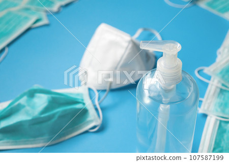 KN95 Medical face mask with alcohol sanitizer gel hand wash bottle on blue background covid-19 Coronavirus prevention concept 107587199