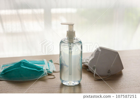 Medical face mask with alcohol sanitizer gel hand wash on wood table for covid-19 Coronavirus prevention concept 107587251
