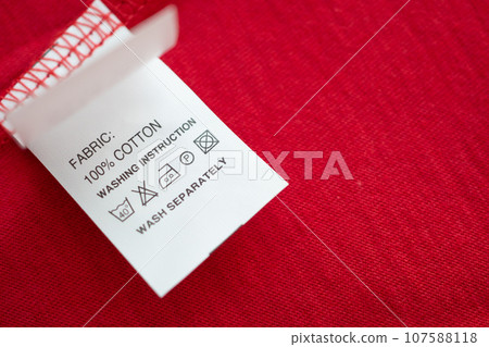 White laundry care washing instructions clothes label on red cotton shirt 107588118