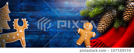 Christmas Tree Decoration On Blue Wooden Background; greeting card or banner design Christmas Tree Decoration On Blue Wooden Background; greeting card or banner design 107589559