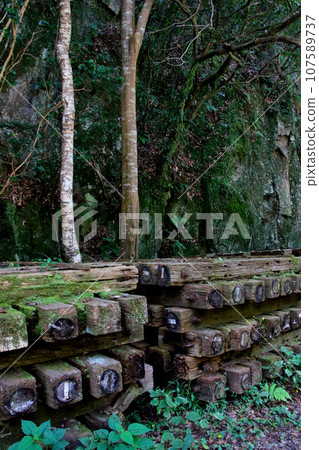 A group of railroad ties piled up at the edge of the abandoned Fukuchiyama Line railway track. A group of railroad ties piled up at the edge of the abandoned Fukuchiyama Line railway track. 107589737