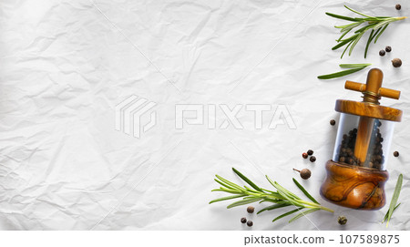 traditional italian pepper shaker and green organic rosemary leaves on white culinary paper background. Ingredient, spice for cooking. collection for culinary banner design traditional italian pepper shaker and green organic rosemary leaves on white culinary paper background. Ingredient, spice for cooking. collection for culinary banner design 107589875
