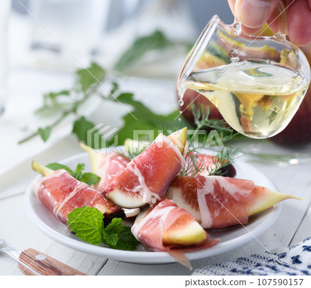 Dishes of fresh figs (figs) and prosciutto (with olive oil) Appetizer Prosciutto figs White background 107590157