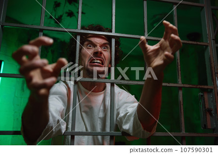 Mentally unstable male patient with attack of rabies locked in cage ward 107590301