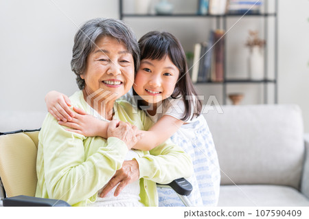 Senior woman in wheelchair and granddaughter 107590409