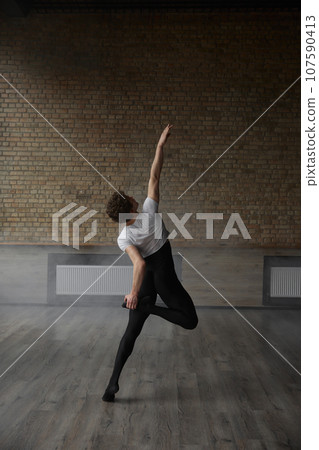 Contemporary ballet male dancer posing for camera performing body stretching Contemporary ballet male dancer posing for camera performing body stretching 107590413