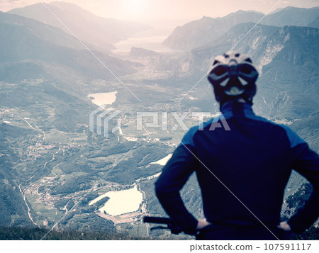 Boy sit on mountain bike and watching from Alps peak 107591117