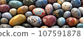 Multi-colored marble stones or beads. Large number of round smooth shiny beautiful rocks. Rounded crystals for healing holistically. Texture, abstract background. Panoramic. 107591878