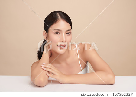 Beautiful young asian woman with clean fresh skin on beige background, Face care, Facial treatment, Cosmetology, beauty and spa, Asian women portrait. Beautiful young asian woman with clean fresh skin on beige background, Face care, Facial treatment, Cosmetology, beauty and spa, Asian women portrait. 107592327