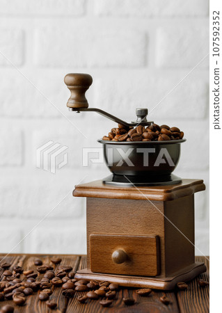 coffee beans in manual grinder on the table coffee beans in manual grinder on the table 107592352