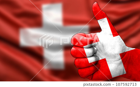 thumbs up in approval with the Swiss flag painted 107592713