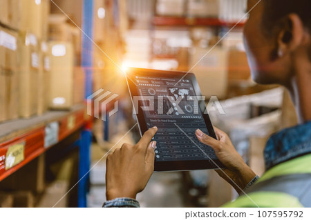 Software Smart warehouse management in tablet computer real time monitoring track goods package delivery. Inventory worker showing digital data dashboard screen for storage logistics supply chain dist Software Smart warehouse management in tablet computer real time monitoring track goods package delivery. Inventory worker showing digital data dashboard screen for storage logistics supply chain dist 107595792