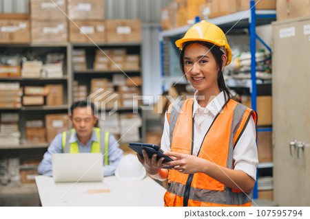 Portrait young woman engineer happy working inventory staff. Southeast Asian teen lady worker standing in factory products shipping warehouse. Portrait young woman engineer happy working inventory staff. Southeast Asian teen lady worker standing in factory products shipping warehouse. 107595794